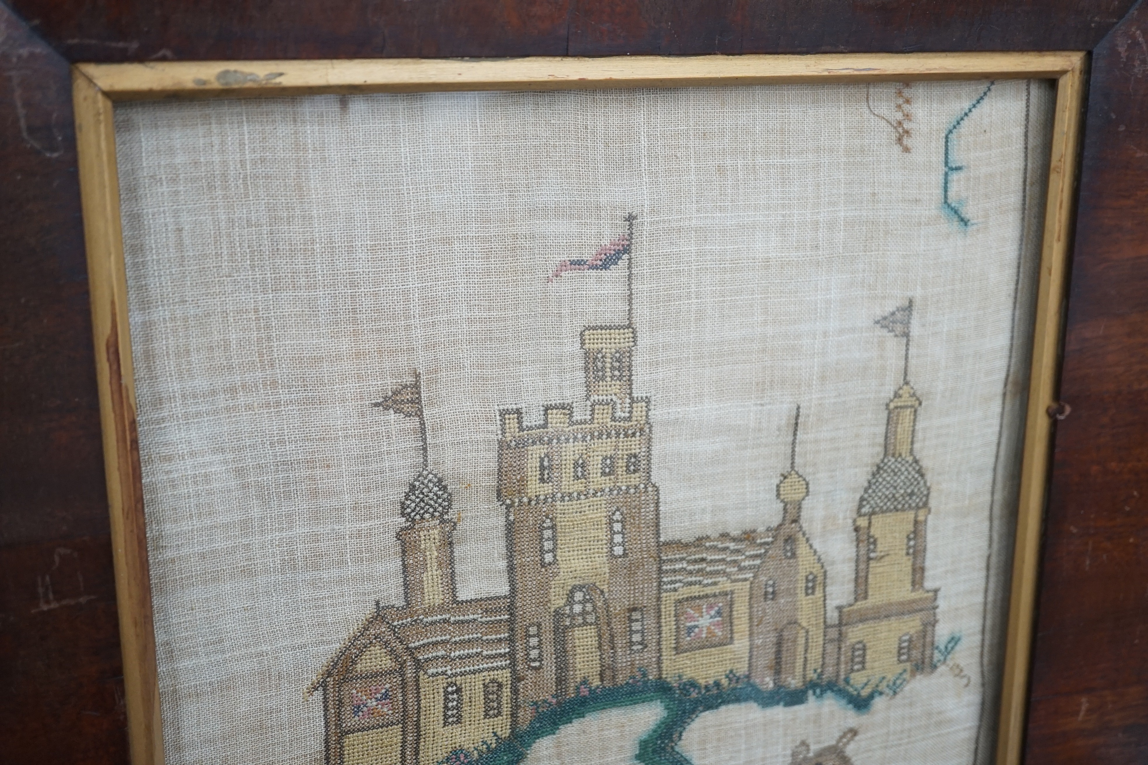 A late Georgian needlework of a leopard and castle , together with a turned wooden framed convex mirror and a similar ebony and gilt framed convex mirror, needlework 31 cms x 36 cms